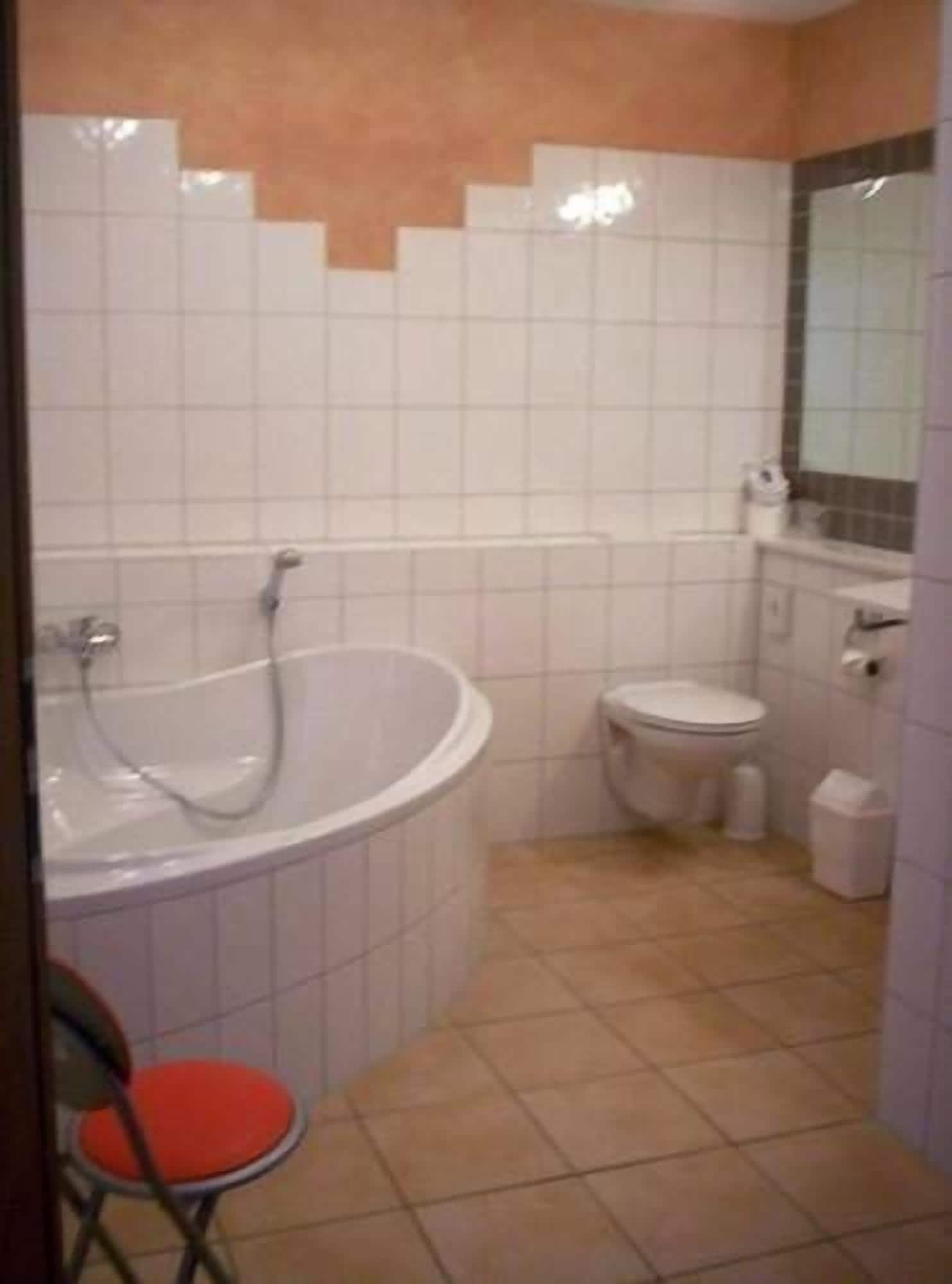 A bathroom with a bathtub, toilet, and a sink.