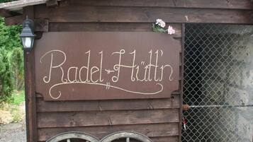 Una estructura de madera rústica con un letrero que dice "Radel Fritzin" y dos ruedas grandes en la parte delantera.
