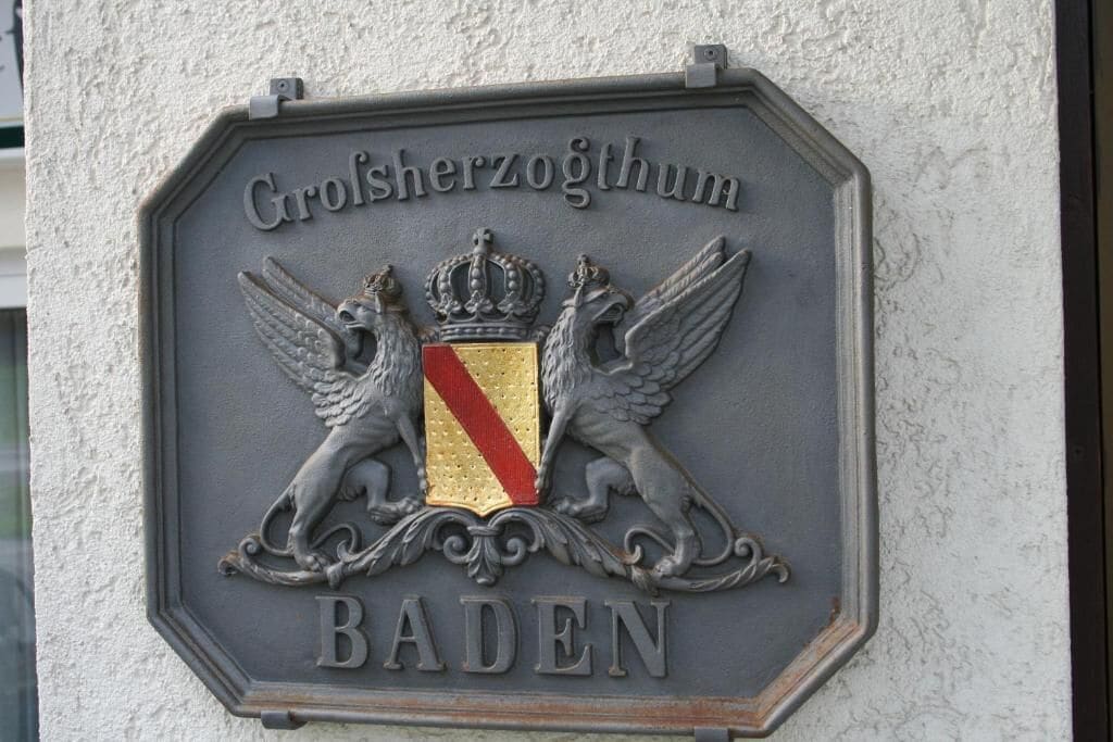 A metal plaque with the inscription "Großerherzogtum Baden" and "BADEN" on a textured wall.