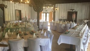 A banquet hall with long tables set for a formal event, featuring white tablecloths, floral centerpieces, and candelabras. - Seltenbacher Hof (Tuttlingen)