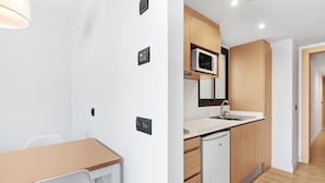 Cocina moderna con microondas, pileta y armarios de madera.