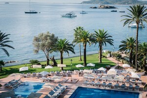 Una piscina techada, una piscina al aire libre, sombrillas