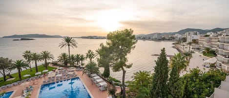 Een binnenzwembad, een buitenzwembad en parasols bij het zwembad