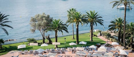 Alberca techada, alberca al aire libre y sombrillas en la alberca