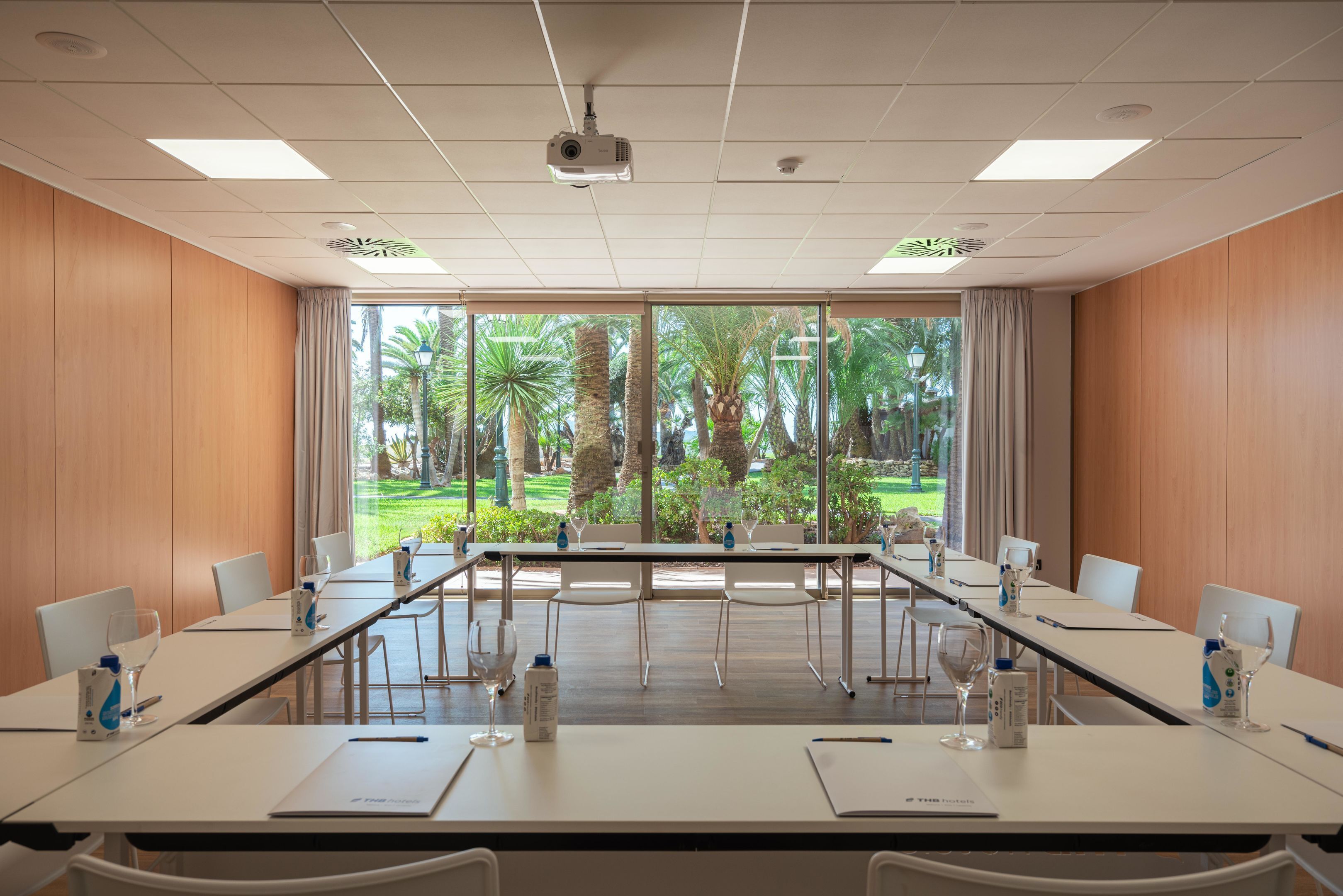 A conference room with a long table, chairs, and a projector.