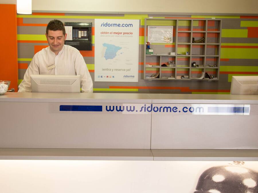 Una recepción con un ordenador, una placa de identificación y un cartel con una dirección web.