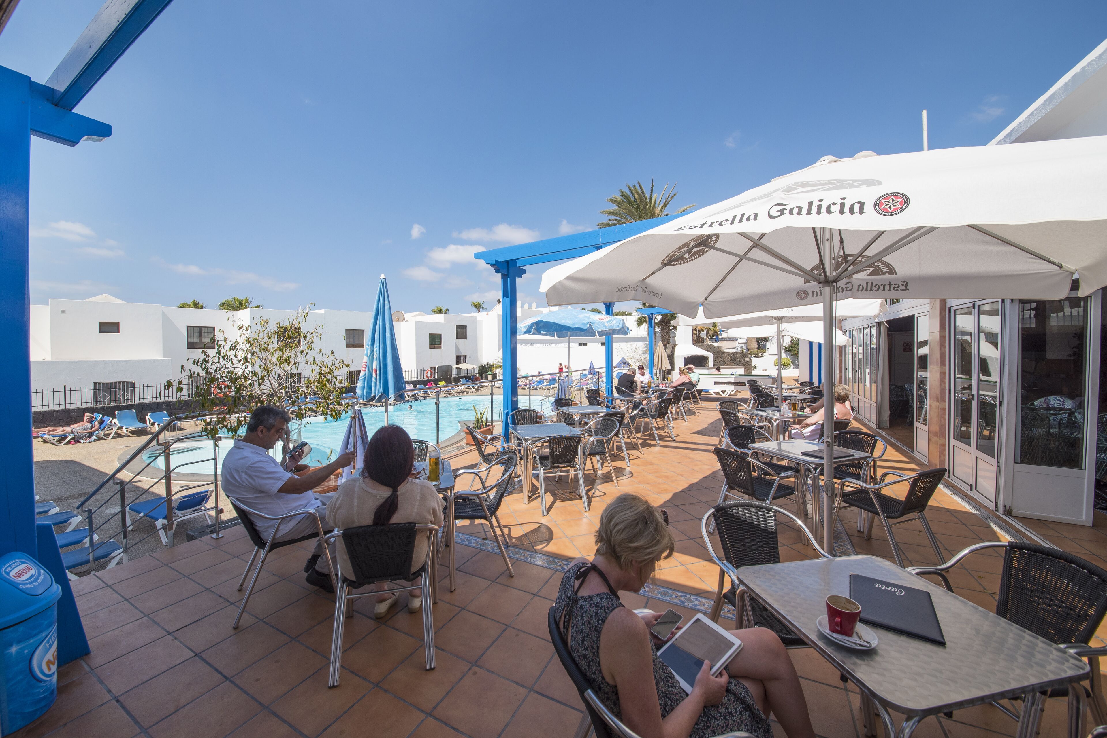 A rooftop pool area with outdoor seating and umbrellas.