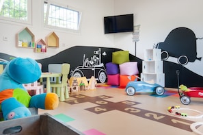 A children's playroom with a large plush toy, a toy car, and a toy train set. - Mas Sola (Santa Coloma de Farners)