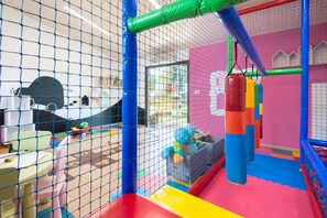 A children's play area with a netted enclosure, colorful play structures, and a slide. - Mas Sola (Santa Coloma de Farners)