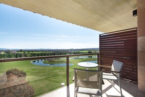 A balcony with a view of a lake, a small table, and two chairs. - Mas Sola (Santa Coloma de Farners)