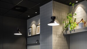 Una moderna zona de recepción con un mostrador de madera, asientos acolchados grises y una pequeña planta.
