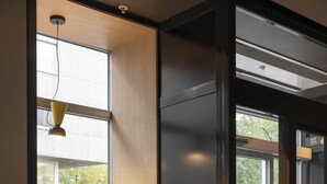 Un interior moderno con un banco junto a una ventana, una puerta con el rótulo 'SAFE TRON' y un suelo de baldosas.