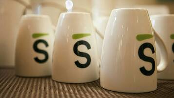 Un conjunto de tazas blancas con un logotipo verde y la letra 'S'.