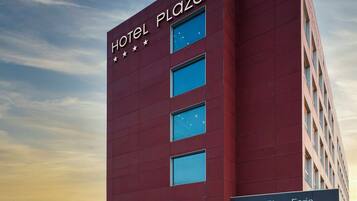 Un edificio moderno de hotel con un letrero destacado que dice 'Hotel Plaza'.