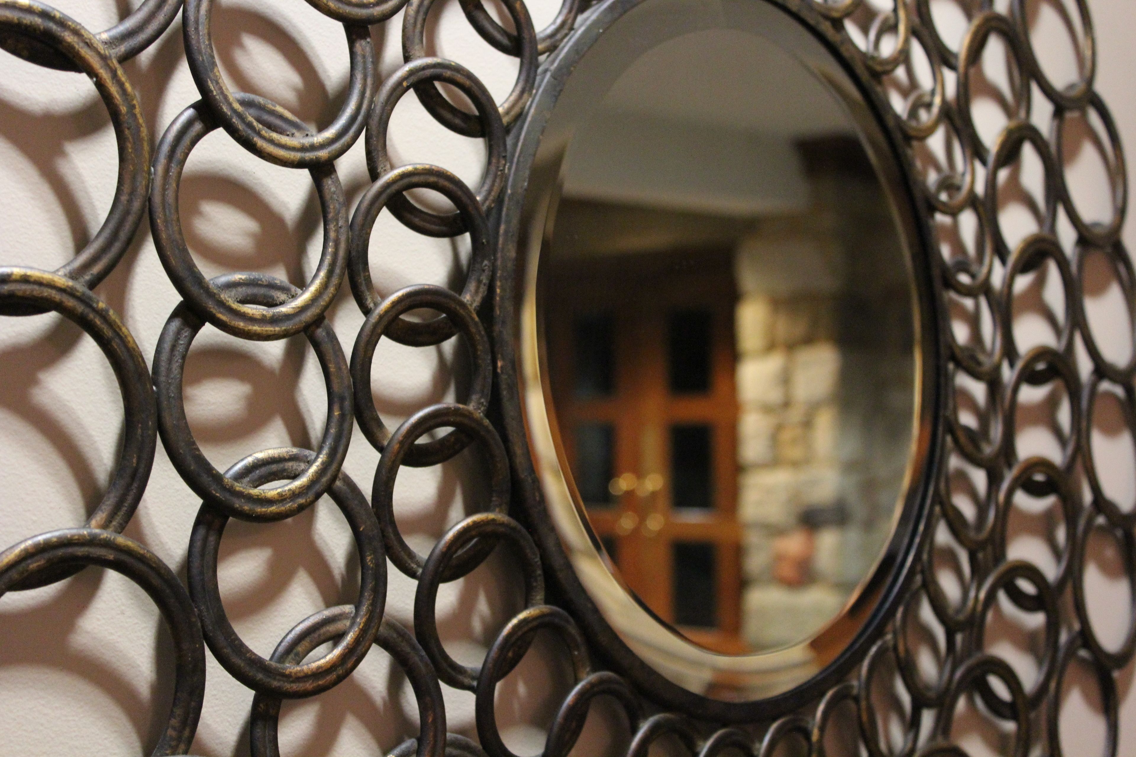 A decorative metal frame with a round mirror.