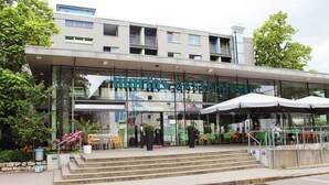 A modern building with a glass facade and outdoor seating area.