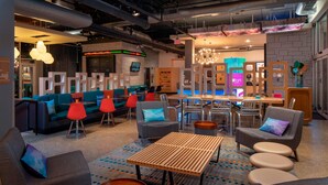 A modern lounge area with sofas, armchairs, and a coffee table. - Aloft by Marriott Rogers-Bentonville (Rogers)