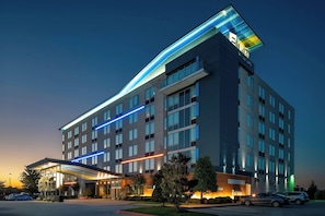 A multi-story hotel with a modern design, featuring a prominent entrance with a covered area and a visible sign. - Aloft by Marriott Rogers-Bentonville (Rogers)