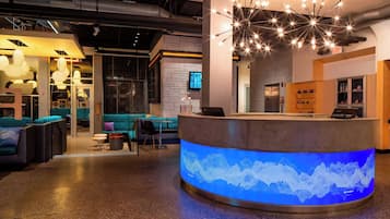 A modern reception area with a curved counter, a digital sound wave display, and a starry light fixture.