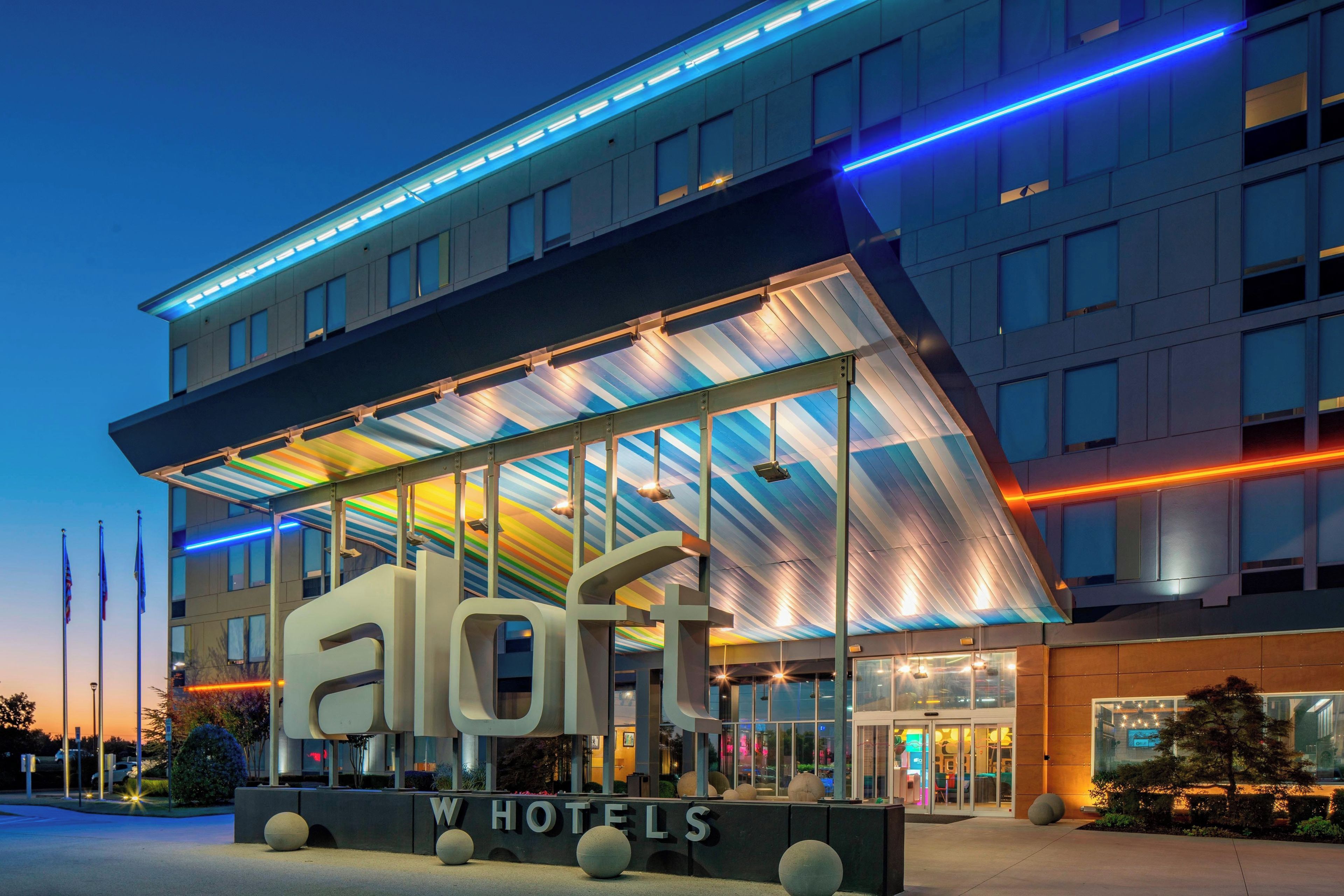 A hotel with a modern design, featuring a large glass facade and a distinctive roof structure.