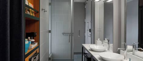 Un baño moderno con dos lavamanos, una ducha y un mueble de tocador con estantes.