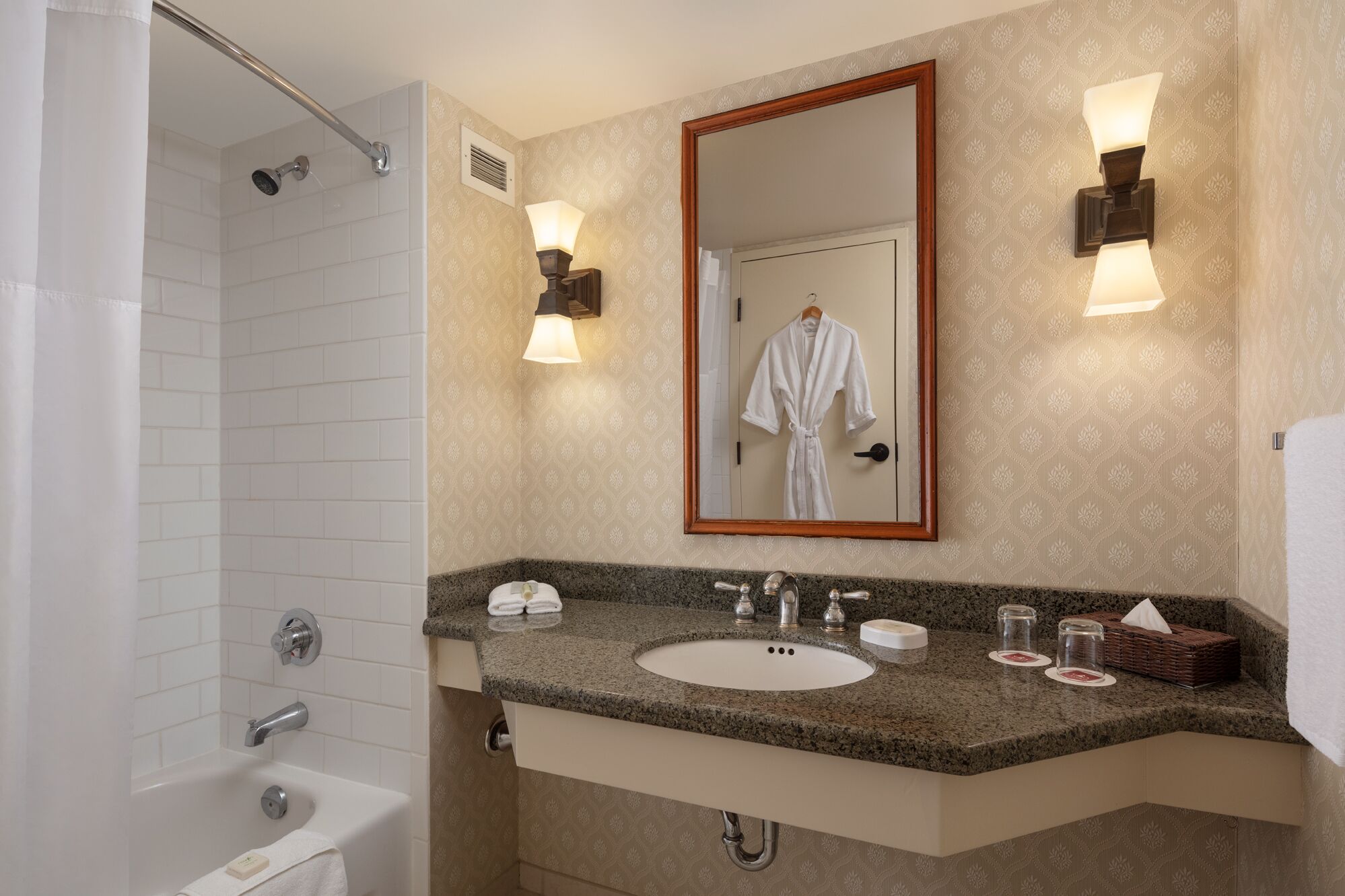 Ein Badezimmer mit Dusche, Waschbecken, Spiegel und Handtuchhalter.