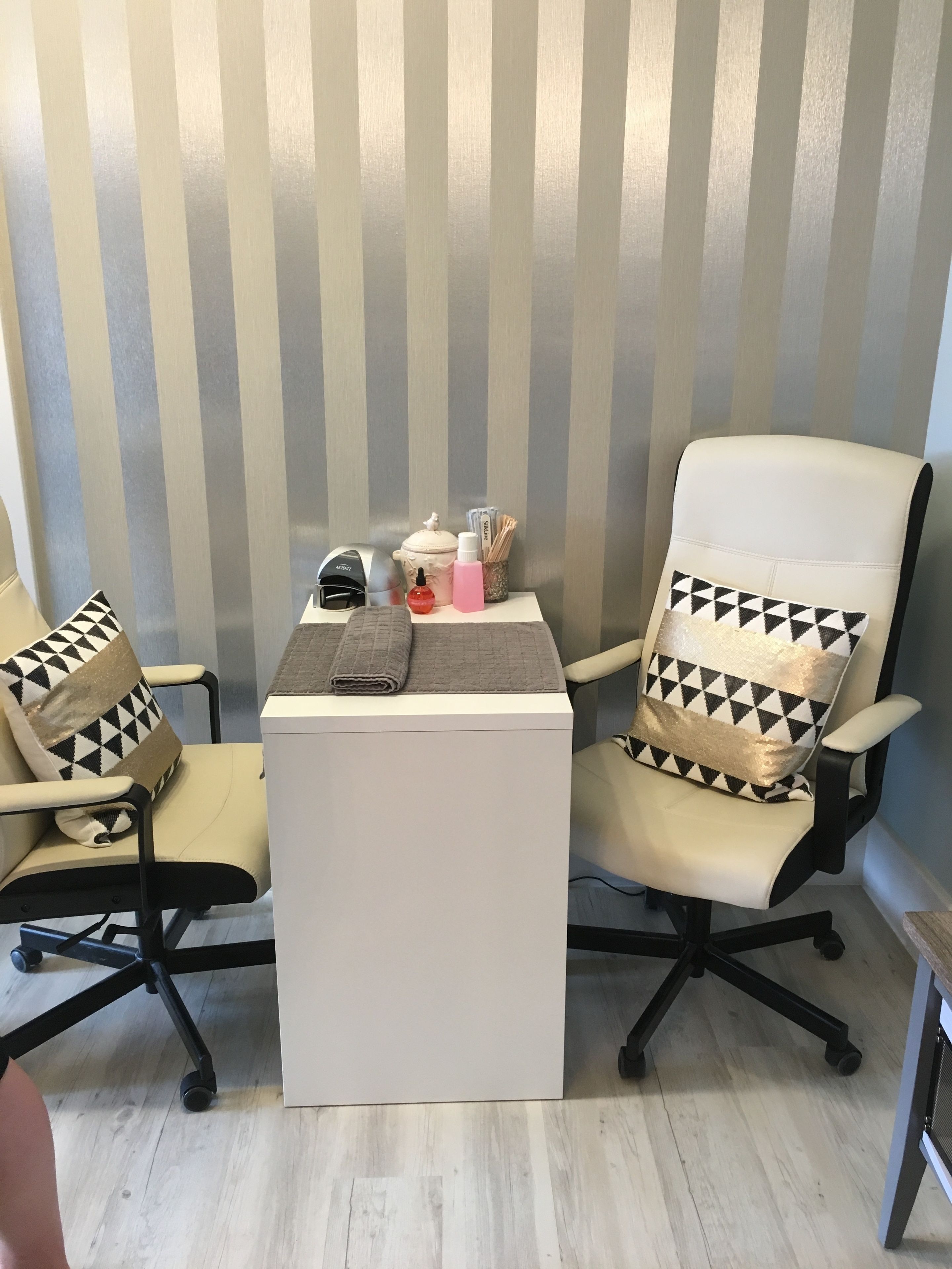 A room with two office chairs, a small white table, and a striped wall.