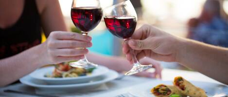 Una mesa de comedor con platos de comida y copas de vino.