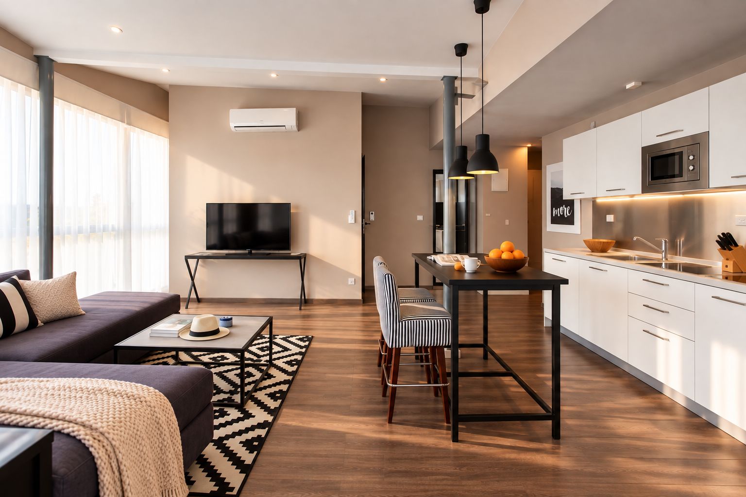 Un salon moderne comprenant un canapé, un téléviseur et un coin repas avec une table et des chaises.