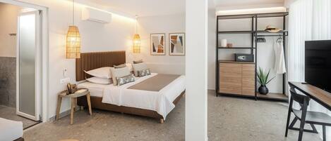 Una habitación de hotel moderna con cama, mesita de noche, lámpara, armario y televisor.