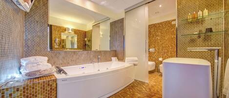 Un bagno moderno con una vasca da bagno ampia, un WC separato e un mobile vanità con specchio.