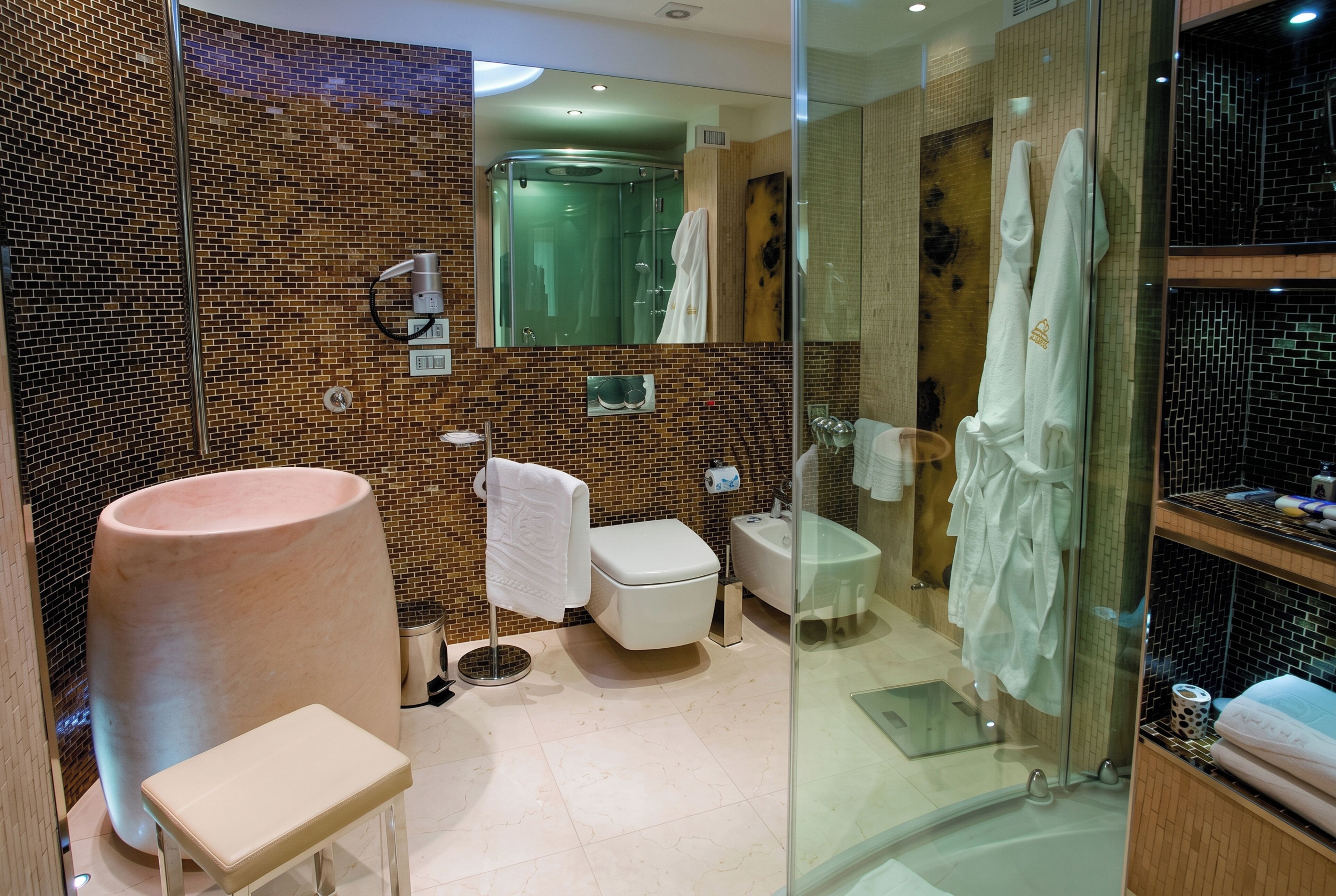 Un bagno moderno con un lavandino grande, un water e un box doccia in vetro.