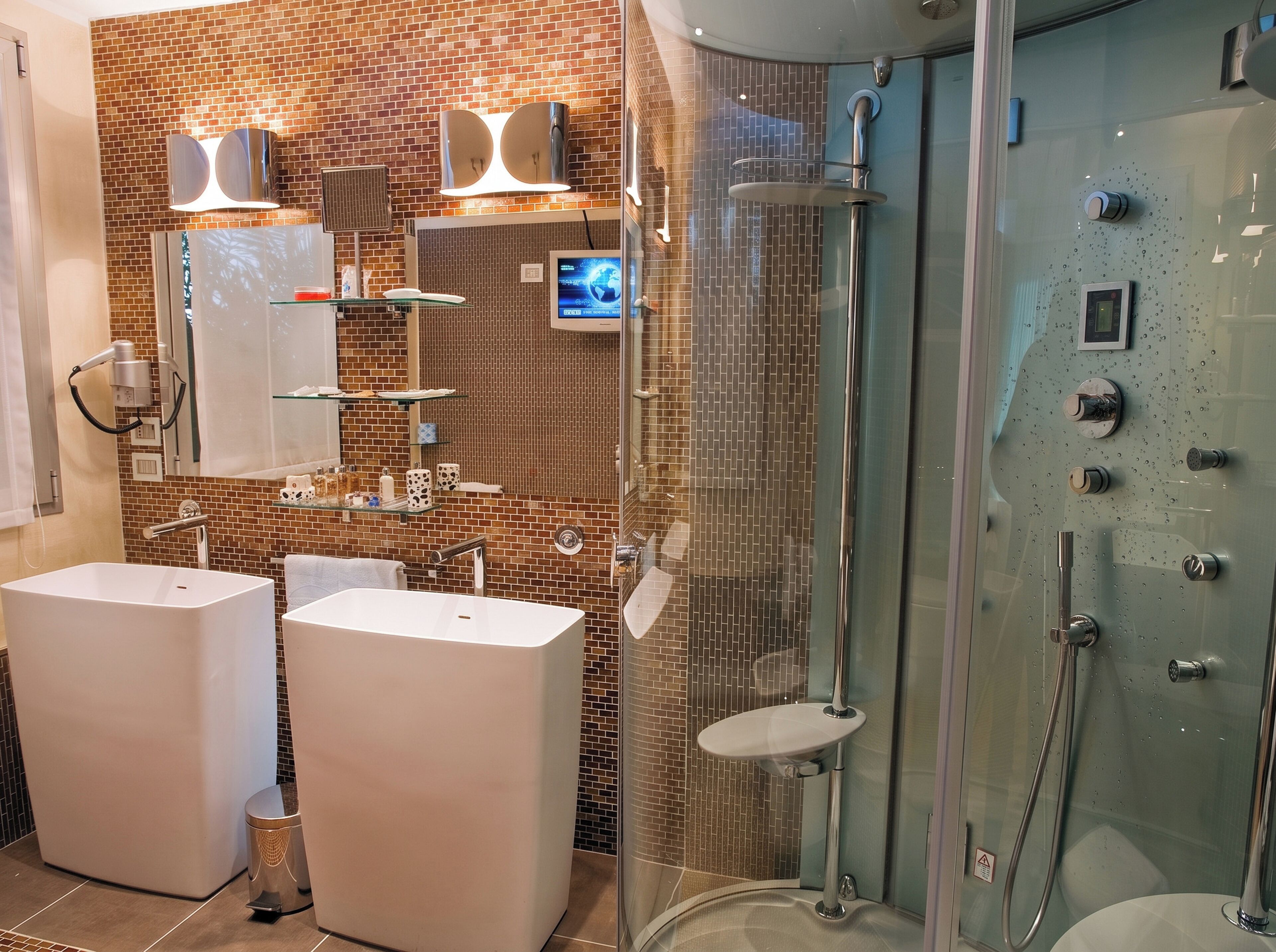 Uma casa de banho moderna com duas lavatórios, cabine de duche em vidro e painel digital.