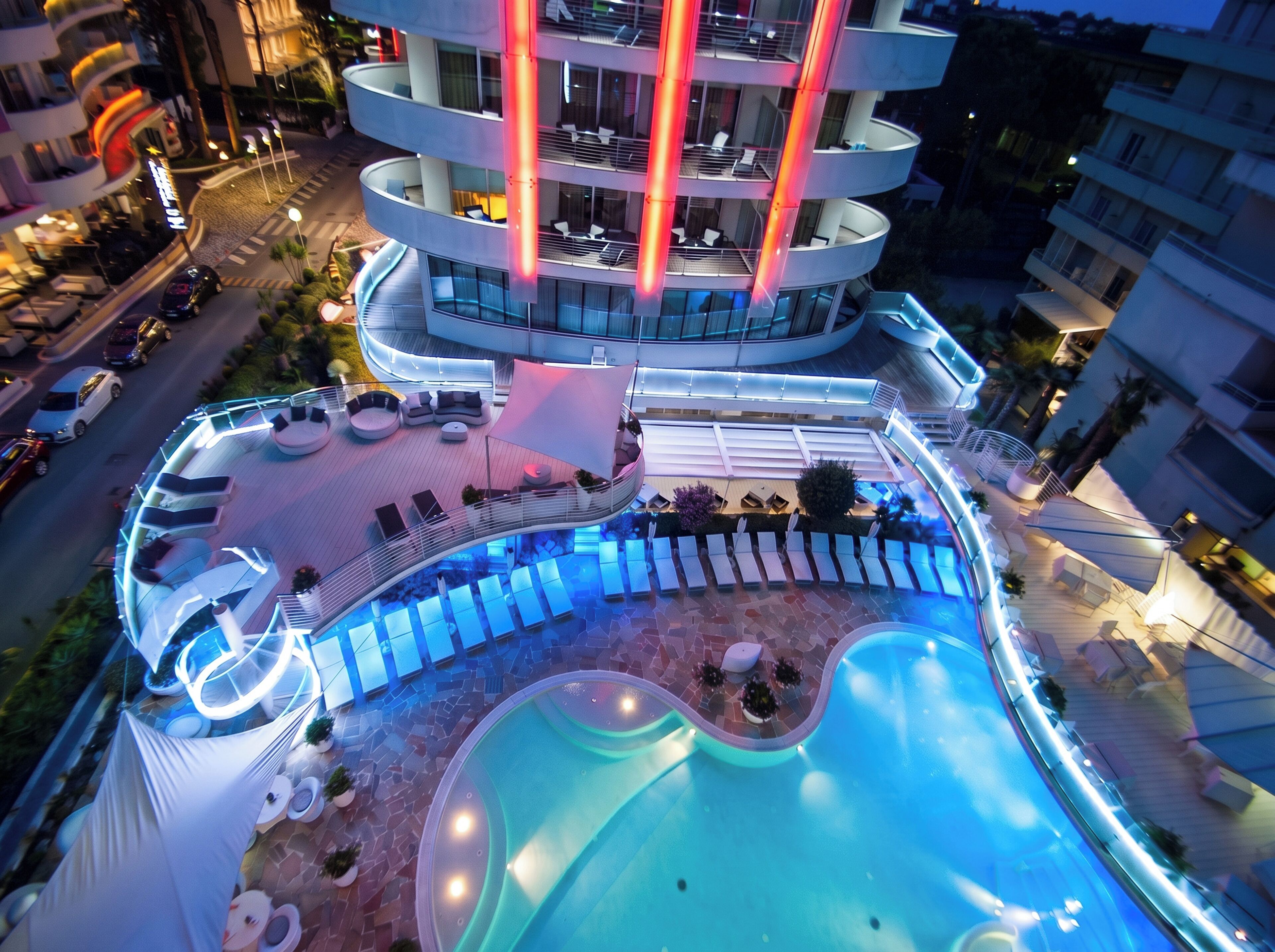 Ein mehrgeschossiges Hotel mit Poolbereich auf dem Dach, inklusive Liegestühlen und Schwimmbecken.
