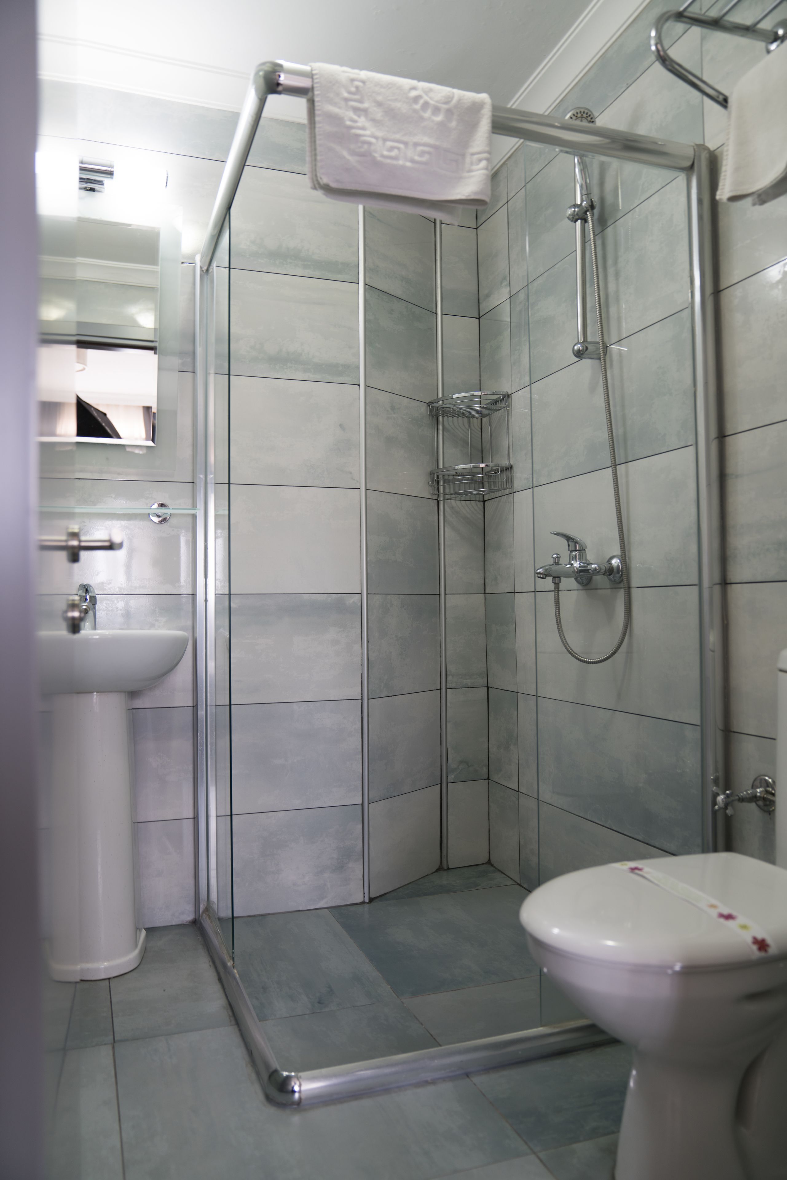 Un baño moderno con ducha de vidrio, inodoro y lavamanos.