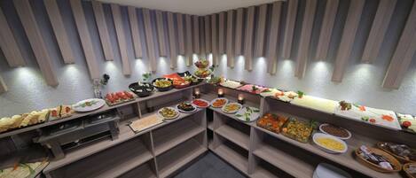 A buffet setup with various food items and a modern interior design.