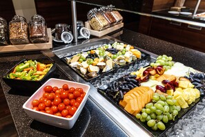 A buffet with various food items including fruits, cheeses, and vegetables. - Hotel & Asia Spa Leoben (Leoben)