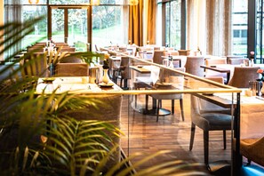 A restaurant with a long dining area, wooden tables, and chairs. - Hotel & Asia Spa Leoben (Leoben)