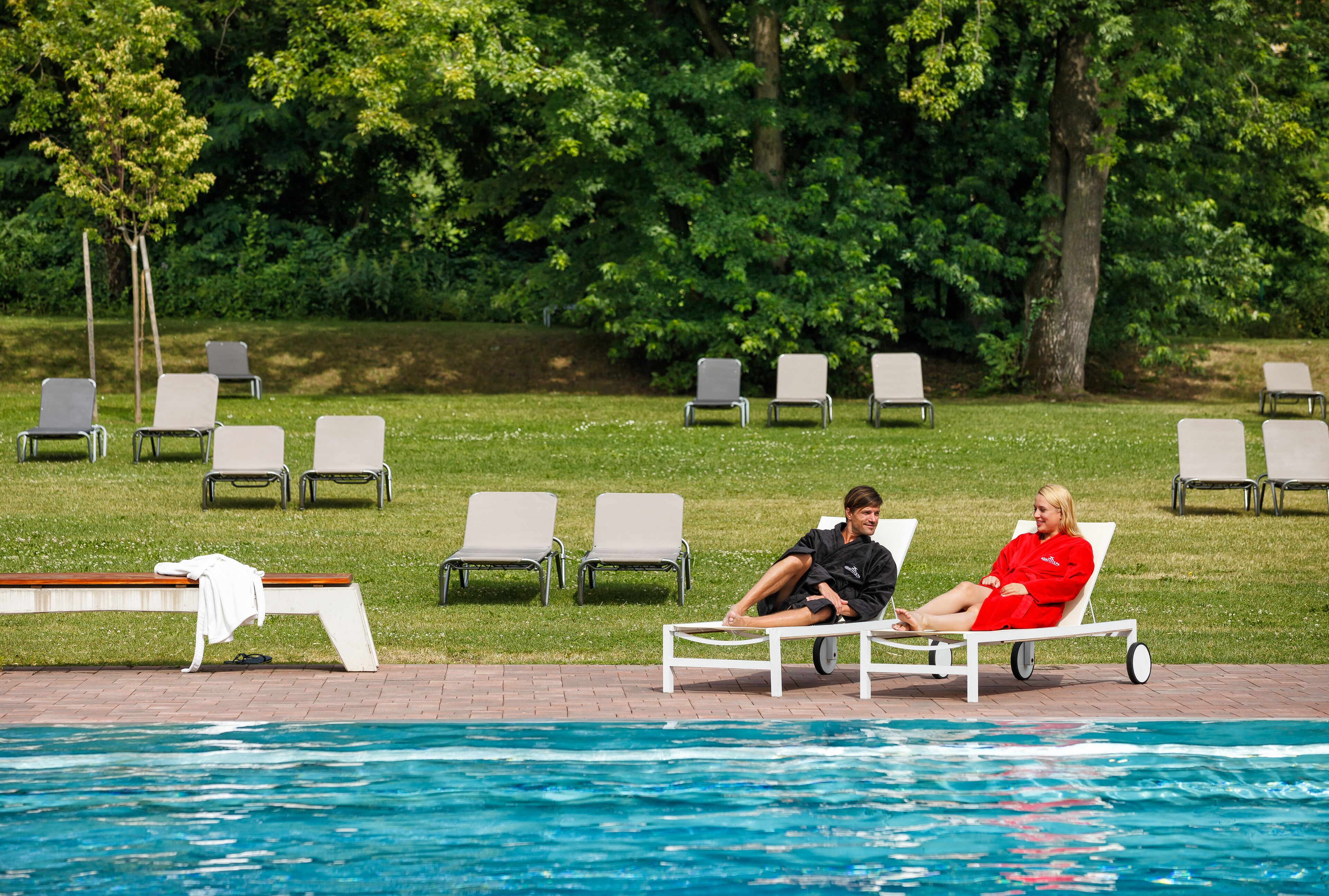 A poolside area with lounge chairs and a pool.