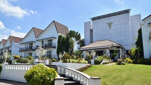 A modern residential complex with multiple white houses, a central staircase, and well-maintained gardens. - Thunderbird Resorts - Rizal (Binangonan)