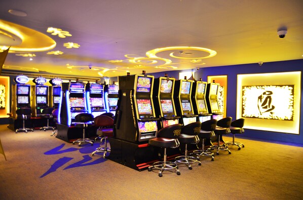 Un espacio de juegos con máquinas tragamonedas y taburetes de bar.