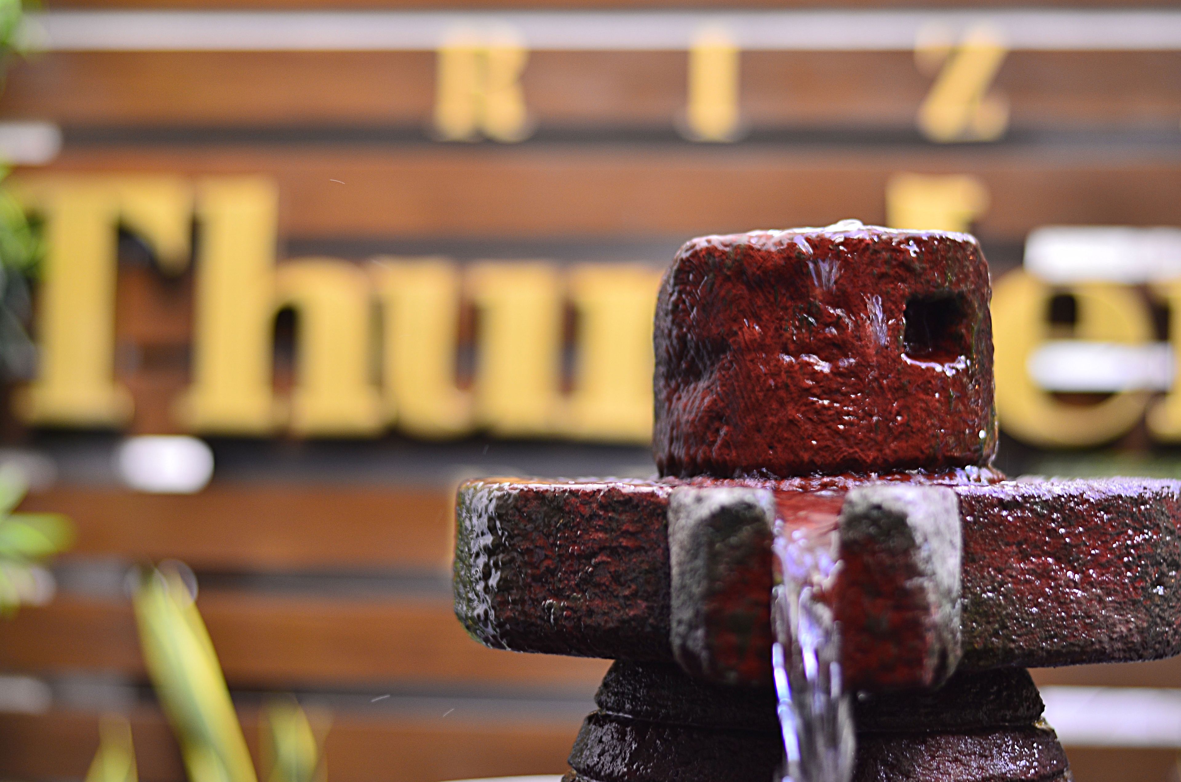 A close-up of a rusty metal object with water dripping from it.