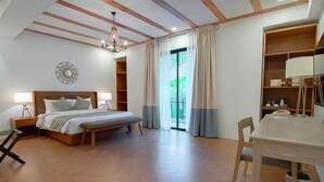 A bedroom with a wooden bed, bedside tables, a desk, and a chair. - Thunderbird Resorts - Rizal (Binangonan)