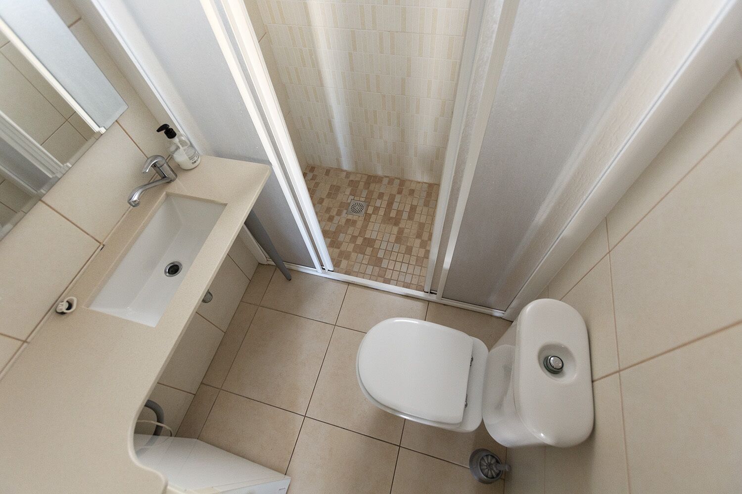 Een badkamer met bad, toilet en douche.