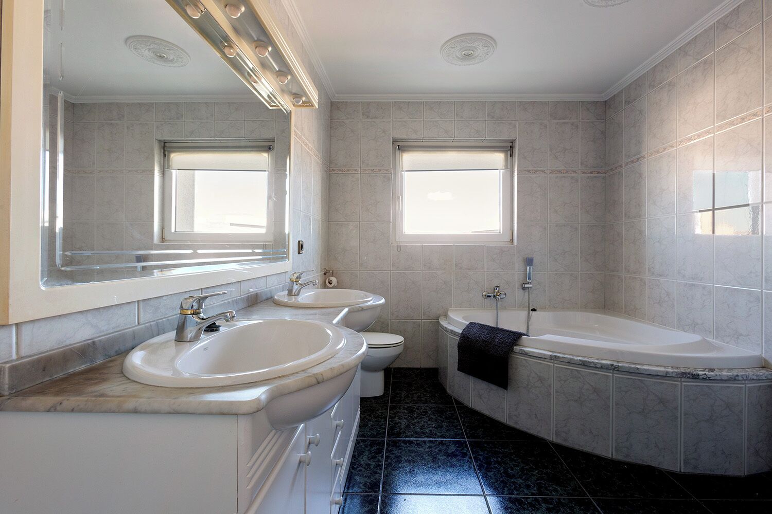 A bathroom with two sinks, a toilet, and a bathtub.