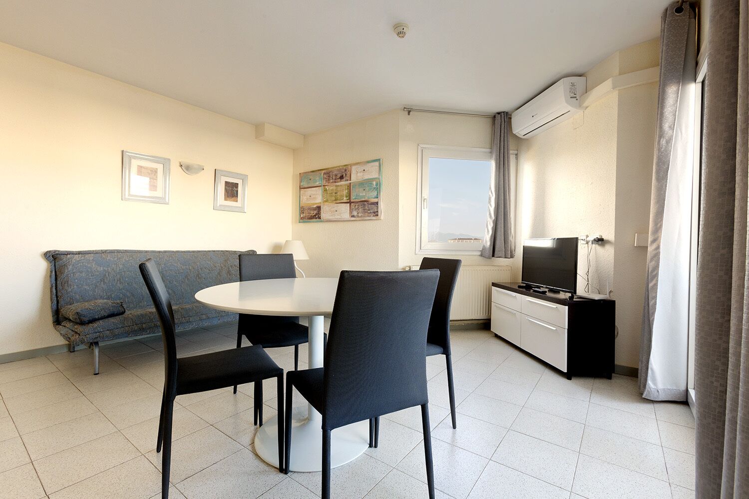 Een knus woongedeelte met een eethoek, een bank, een televisie en een kitchenette.