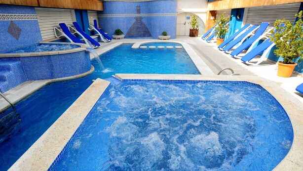 Une piscine dotée de plusieurs couloirs de nage et de chaises longues.