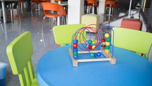 A children's play area with a blue table and colorful chairs.