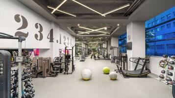 A gym with exercise equipment, treadmills, and weights.