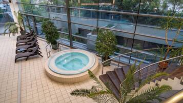 Terraza en la azotea con jacuzzi, sillones de descanso y plantas en macetas.
